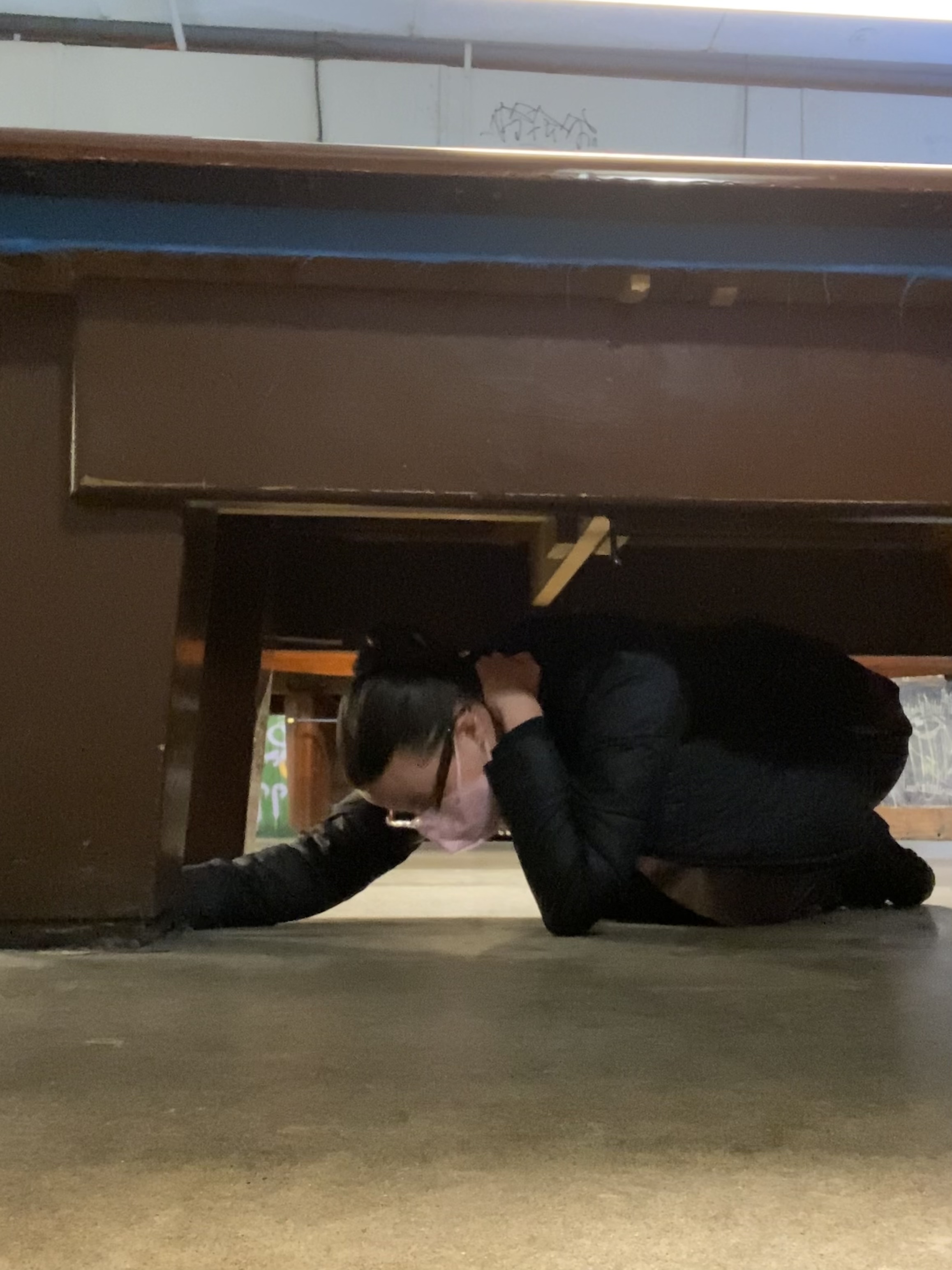 student ducking underneath pool table